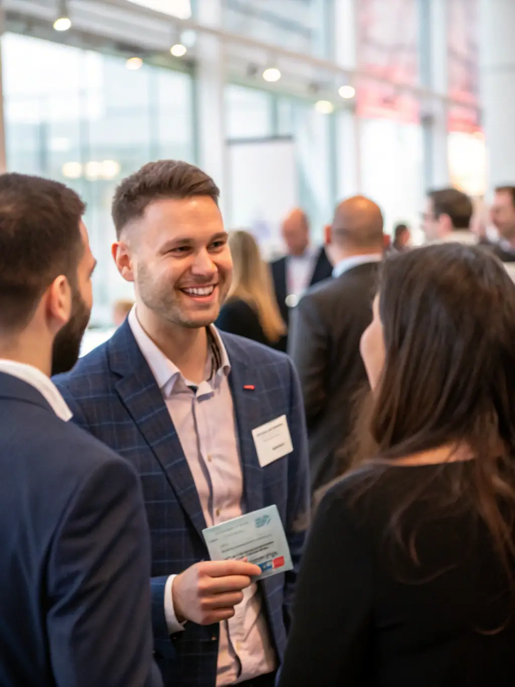 A professional using a digital business card to seamlessly connect with a potential client at a networking event, highlighting the platform's ease of sharing.